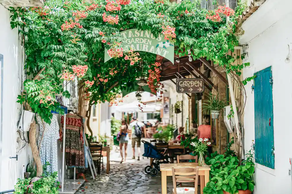 a flower-covered restaurant archway on a narrow village street