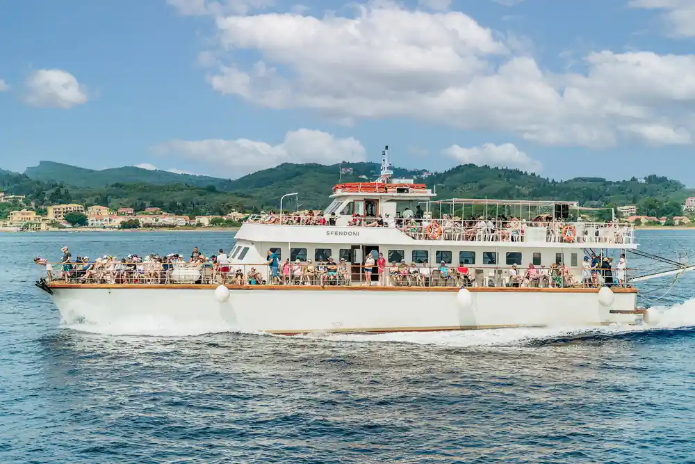 the full cruise boat under way with its upper deck crowded