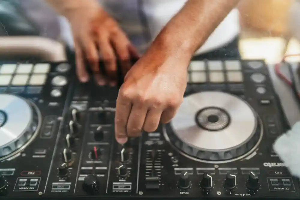 hands working a DJ controller on the deck