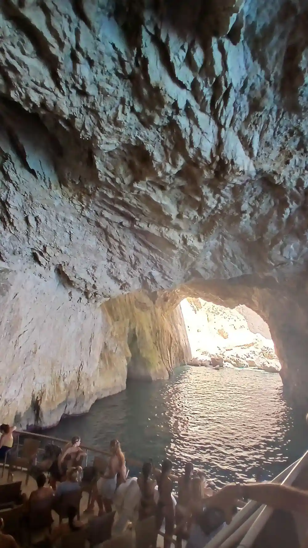 looking out of a cave mouth to bright water beyond