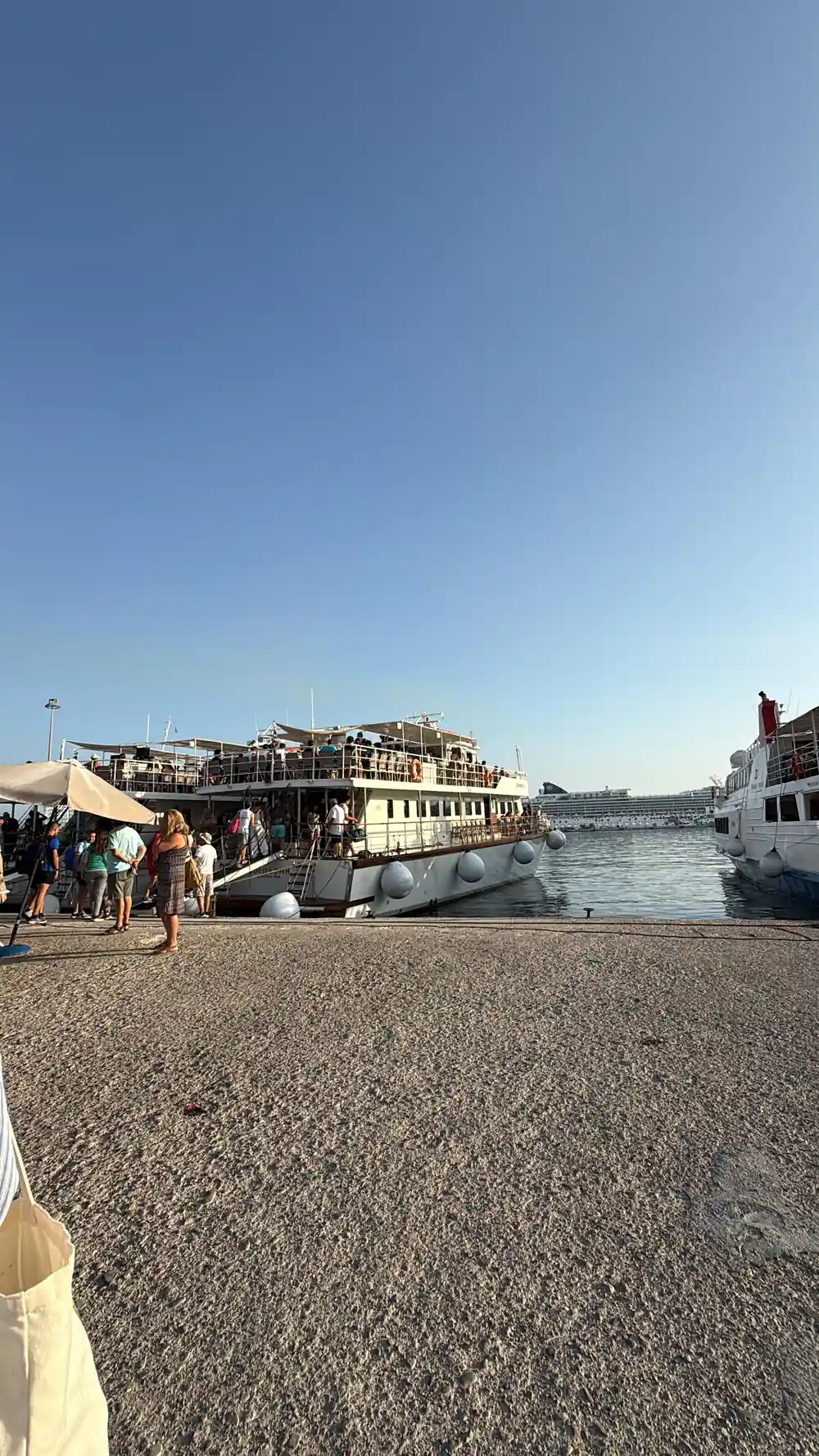passengers boarding the cruise boat alongside a stone quay