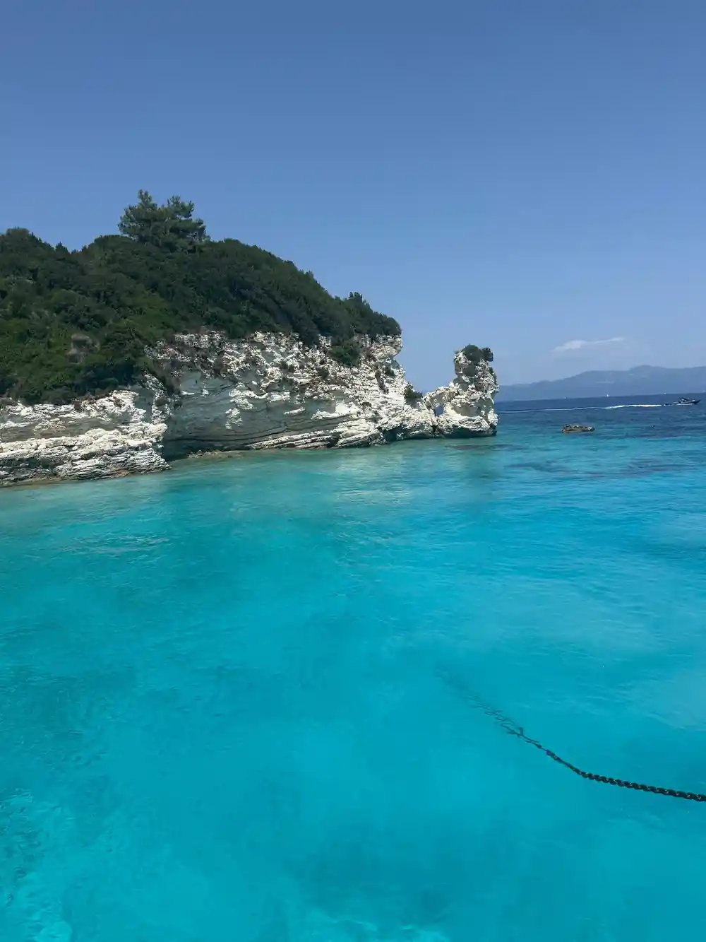 a small rock stack close inshore in glassy turquoise water