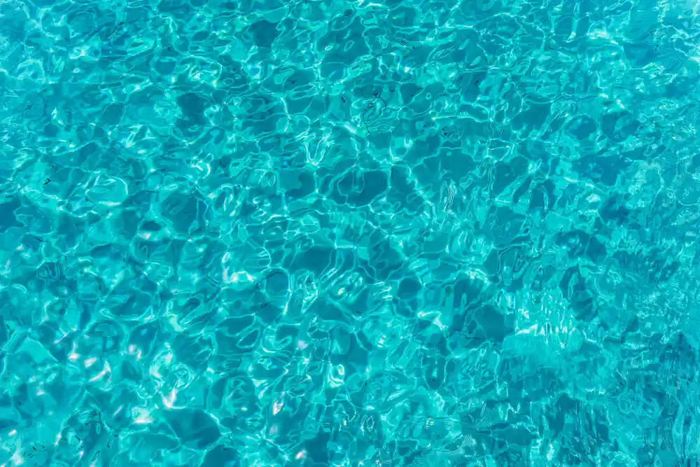 sunlight patterning the surface of impossibly clear turquoise water