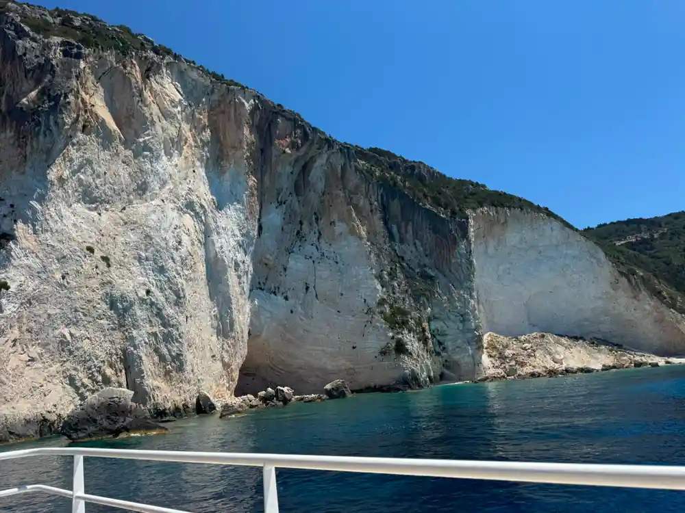 the white cliff face rising directly out of deep water beside the rail