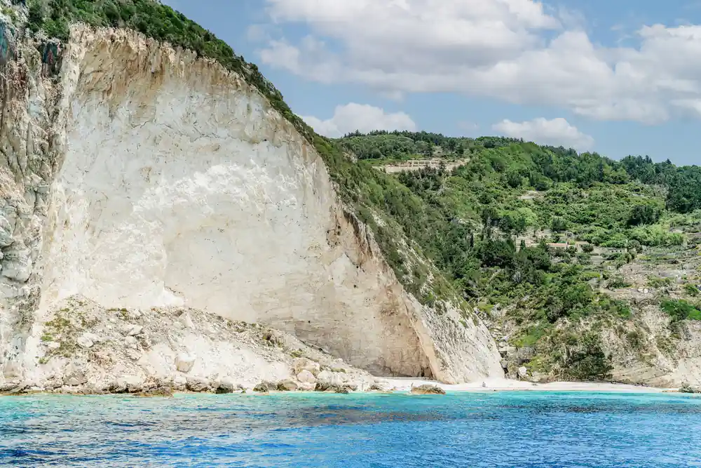 the white Erimitis cliffs dropping straight into deep blue water