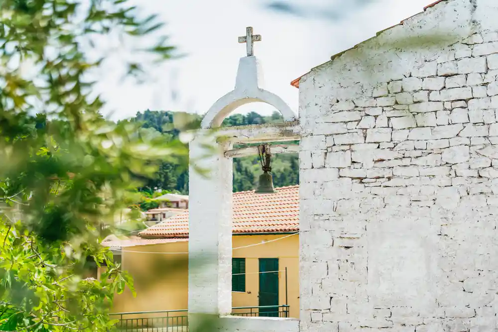 a whitewashed bell arch above terracotta roofs in the village
